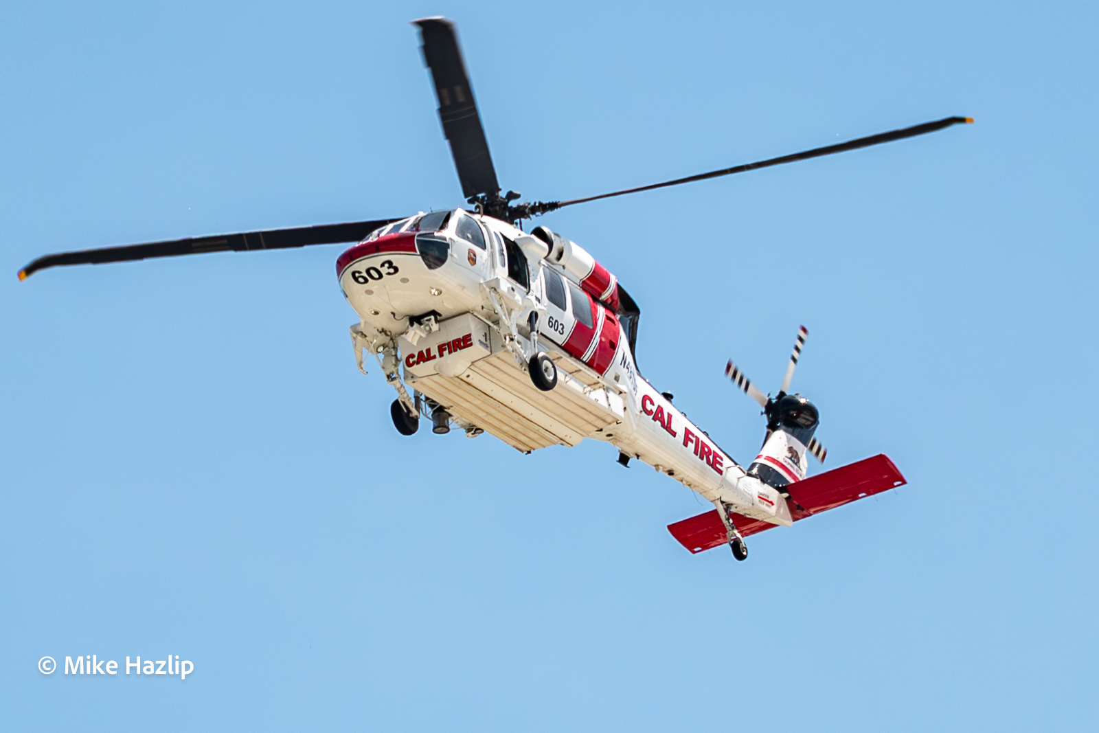 CAL FIRE Fire Hawk S70i helicopter flies overhead.